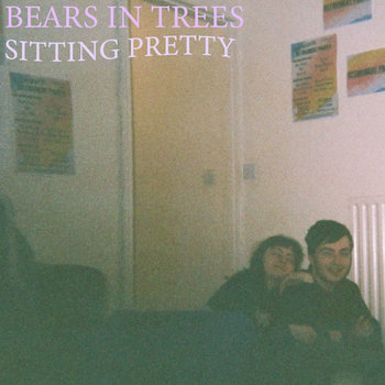 the album cover of "sitting pretty". it shows tba. when you hover the image, it has a greyscale filter and the album title is visible on it. clicking on this image will take you to a page with more info!