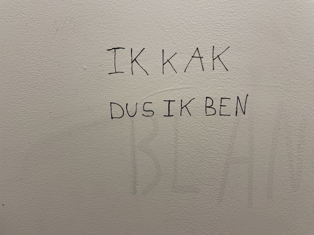 Translated from dutch: 'I shit therefore I am' in thin black writing.