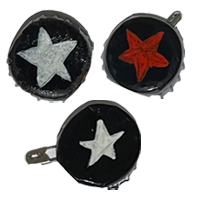 Three black pins. Two of them have a white star, one has a red one.
